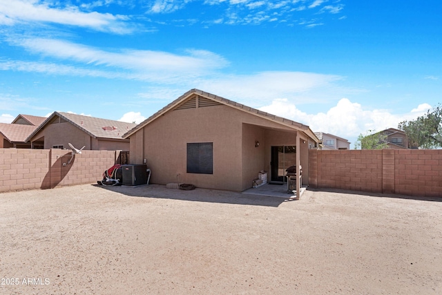back of house with central AC unit, a fenced backyard, a patio area, and stucco siding