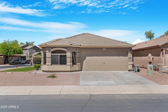 view of front of house with an attached garage, stucco siding, a tiled roof, and concrete driveway