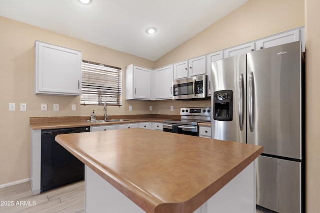 kitchen with white cabinets, stainless steel appliances, a sink, and light wood-type flooring