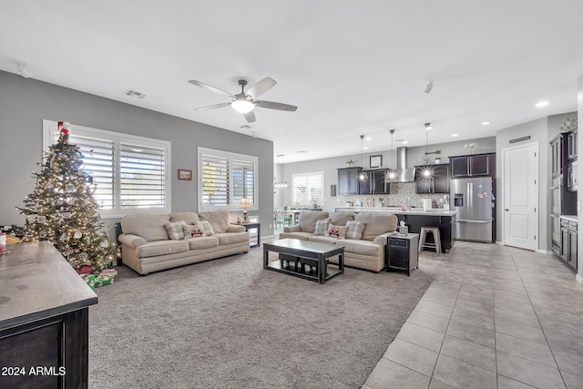 tiled living room featuring ceiling fan and a healthy amount of sunlight