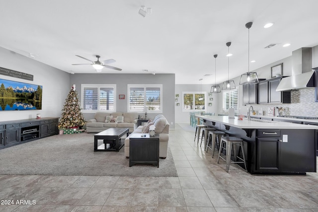 tiled living room featuring ceiling fan and sink