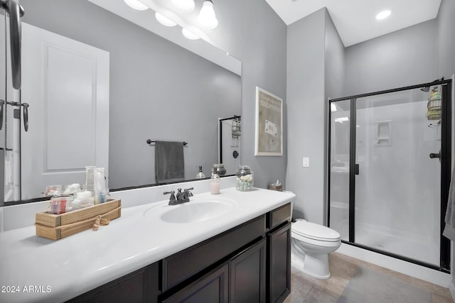 bathroom with tile patterned flooring, vanity, toilet, and a shower with shower door