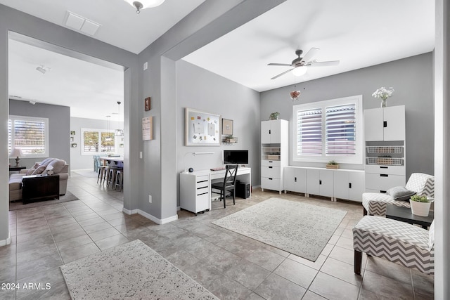 living room with ceiling fan and light tile patterned flooring