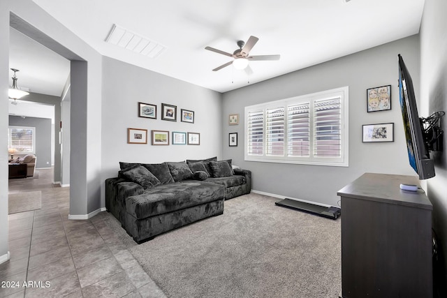 carpeted living room with ceiling fan