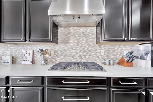 kitchen with backsplash, wall chimney range hood, and stainless steel gas cooktop