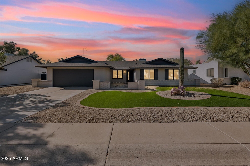 view of front of property with a yard and a garage