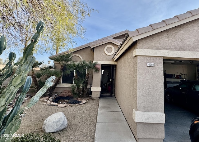 doorway to property with stucco siding and a tiled roof