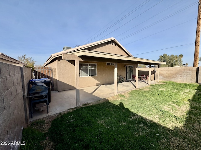 back of house featuring a fenced backyard, stucco siding, a lawn, and a patio