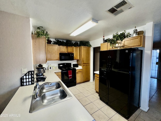 kitchen with visible vents, black appliances, light countertops, a textured ceiling, and a sink