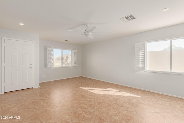 tiled spare room featuring ceiling fan