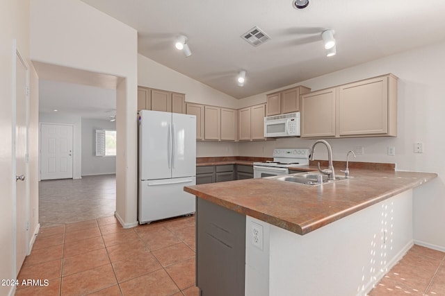 kitchen with lofted ceiling, white appliances, sink, kitchen peninsula, and light tile patterned floors