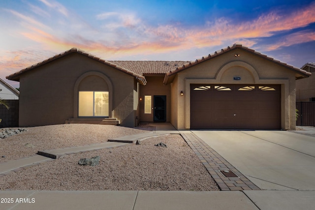 7736 W Tumblewood Dr, Peoria, AZ 85382 - mediterranean / spanish home featuring a garage, driveway, a tile roof, and stucco siding