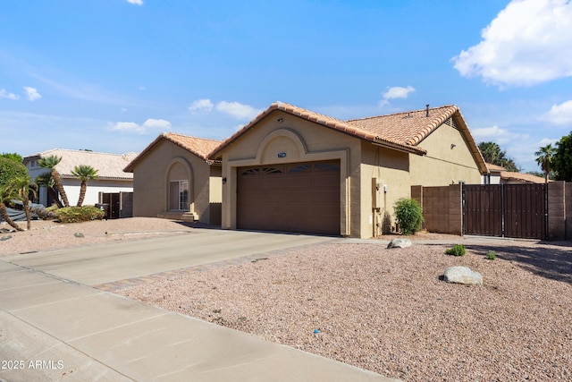7736 W Tumblewood Dr, Peoria, AZ 85382 - mediterranean / spanish-style home featuring stucco siding, a garage, concrete driveway, a tile roof, and a gate