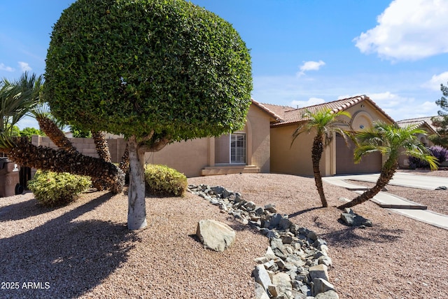7736 W Tumblewood Dr, Peoria, AZ 85382 - view of front of home with an attached garage, a tiled roof, and stucco siding