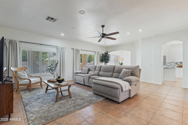 7736 W Tumblewood Dr, Peoria, AZ 85382 - living area featuring arched walkways, ceiling fan, recessed lighting, and light tile patterned floors