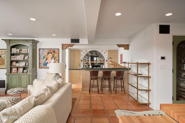 tiled living room featuring bar area