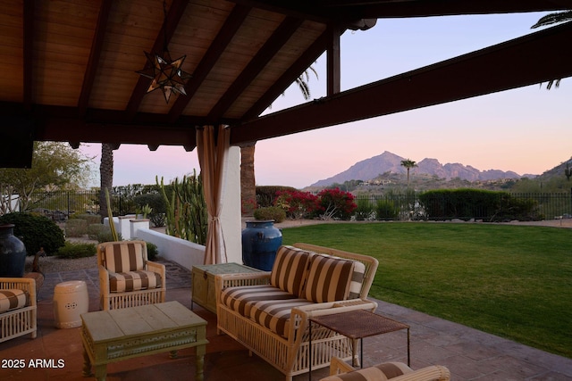 patio terrace at dusk featuring a yard, a gazebo, ceiling fan, a mountain view, and outdoor lounge area