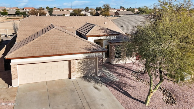 view of front of home featuring a garage, a tile roof, and a residential view