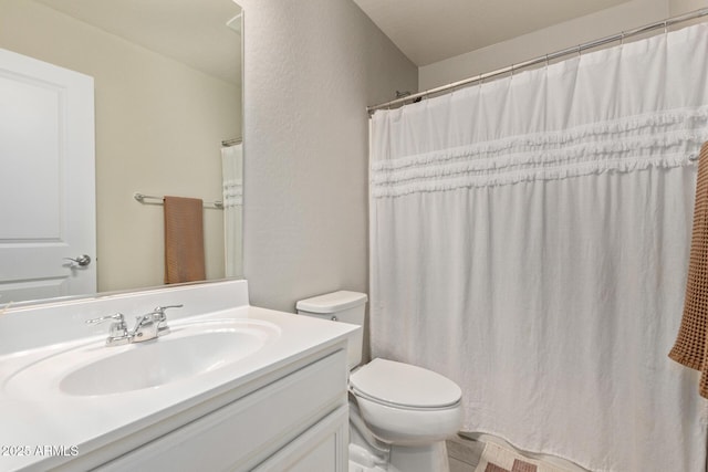 bathroom with a shower with curtain, vanity, and toilet