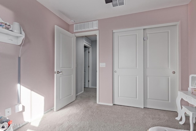 carpeted bedroom featuring baseboards, visible vents, and a closet