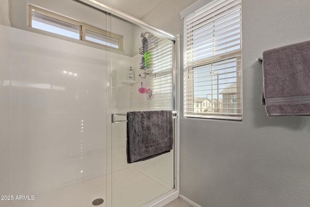 full bath featuring a shower stall and baseboards