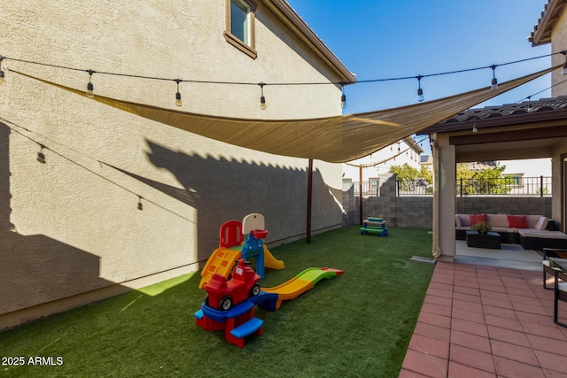 view of jungle gym with a patio area, outdoor lounge area, a lawn, and a fenced backyard