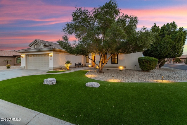 view of front of property with a garage and a lawn