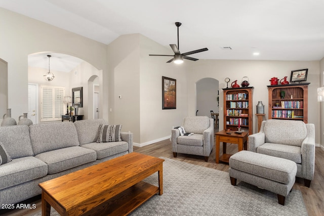 living room with hardwood / wood-style flooring, lofted ceiling, and ceiling fan