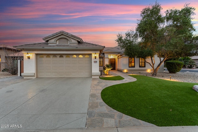 view of front of property with a garage and a lawn