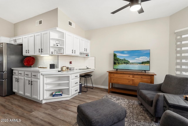 kitchen with ceiling fan, white cabinetry, dark hardwood / wood-style flooring, backsplash, and stainless steel fridge