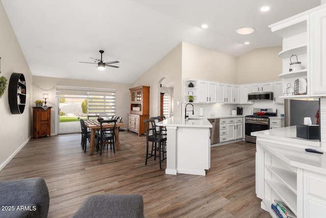 kitchen featuring white cabinetry, decorative backsplash, a kitchen breakfast bar, sink, and stainless steel appliances