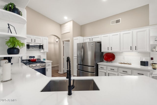 kitchen with sink, range hood, white cabinetry, and stainless steel appliances