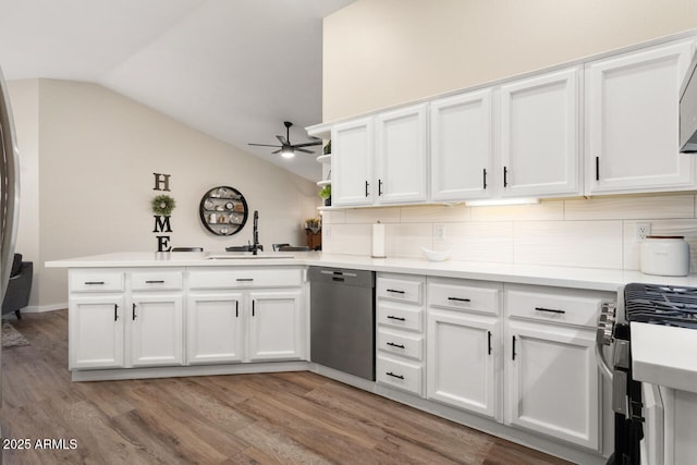 kitchen with white cabinetry, stainless steel appliances, sink, kitchen peninsula, and vaulted ceiling