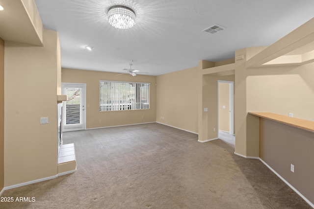 unfurnished room with carpet, visible vents, baseboards, and ceiling fan with notable chandelier