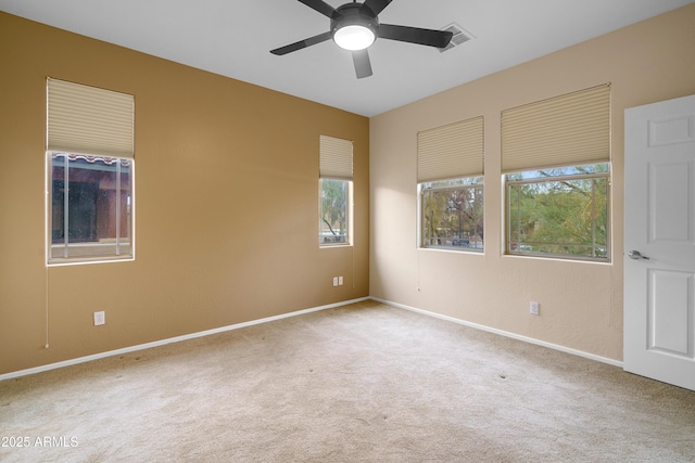 spare room featuring ceiling fan, carpet flooring, visible vents, and baseboards