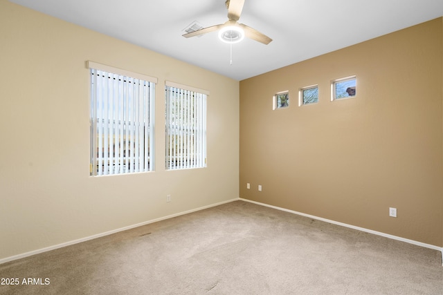 carpeted spare room with ceiling fan, visible vents, and baseboards