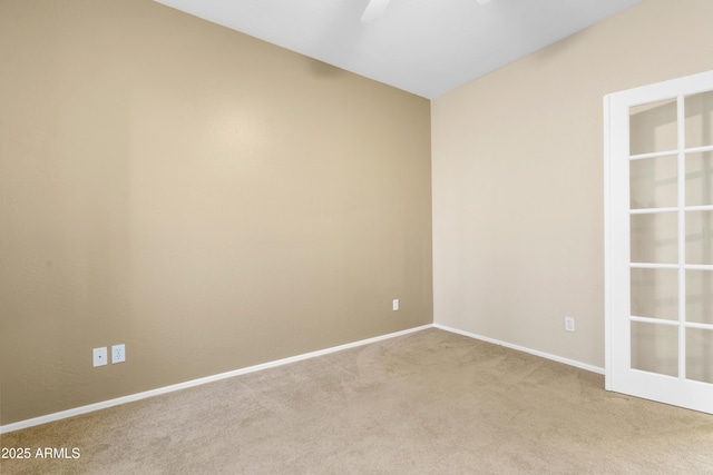 empty room featuring ceiling fan, carpet floors, and baseboards