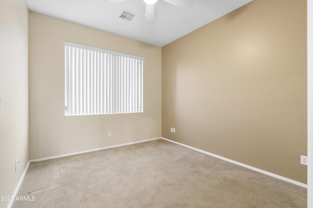 carpeted spare room with baseboards, visible vents, and a ceiling fan