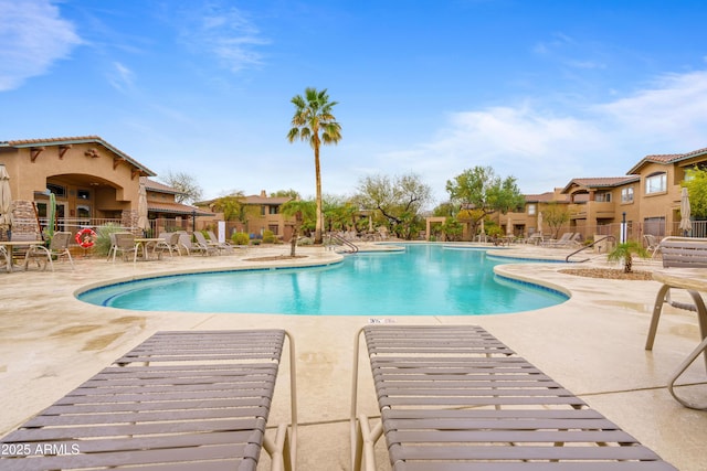 pool with a patio area and fence