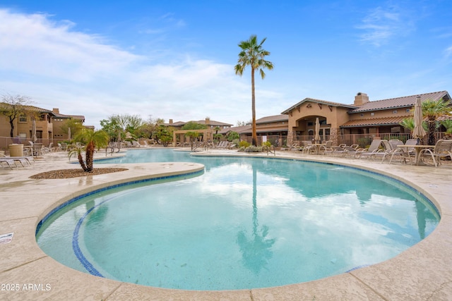 community pool featuring a patio and fence