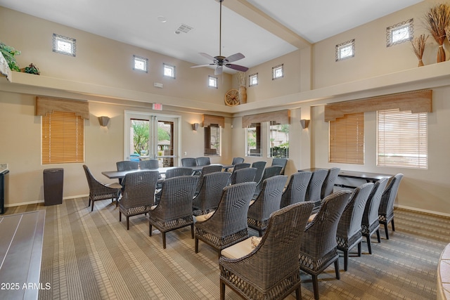 cinema featuring a towering ceiling, baseboards, visible vents, and a ceiling fan