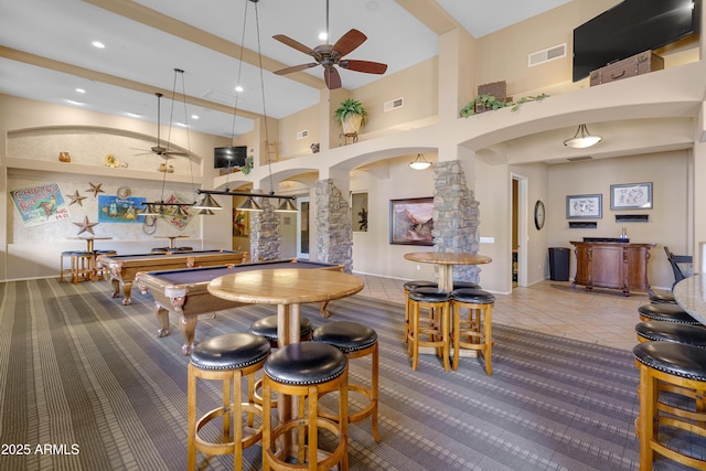 game room with ornate columns, visible vents, arched walkways, and a ceiling fan