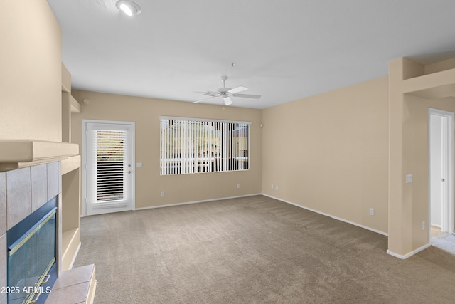 unfurnished living room featuring ceiling fan, baseboards, a tiled fireplace, and carpet flooring