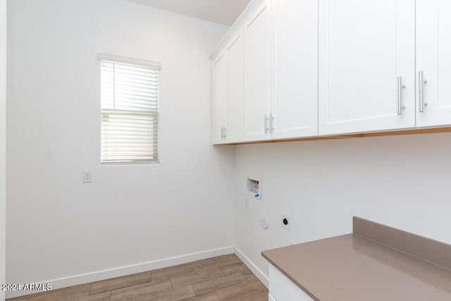 clothes washing area featuring hookup for an electric dryer, cabinets, washer hookup, and light wood-type flooring