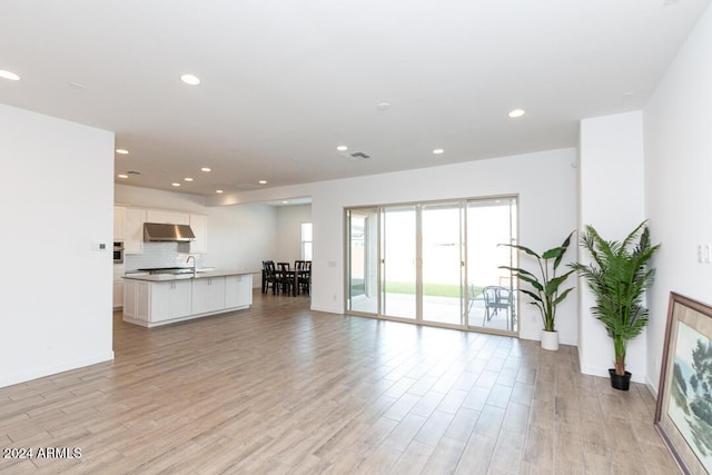 unfurnished living room featuring light hardwood / wood-style flooring and sink