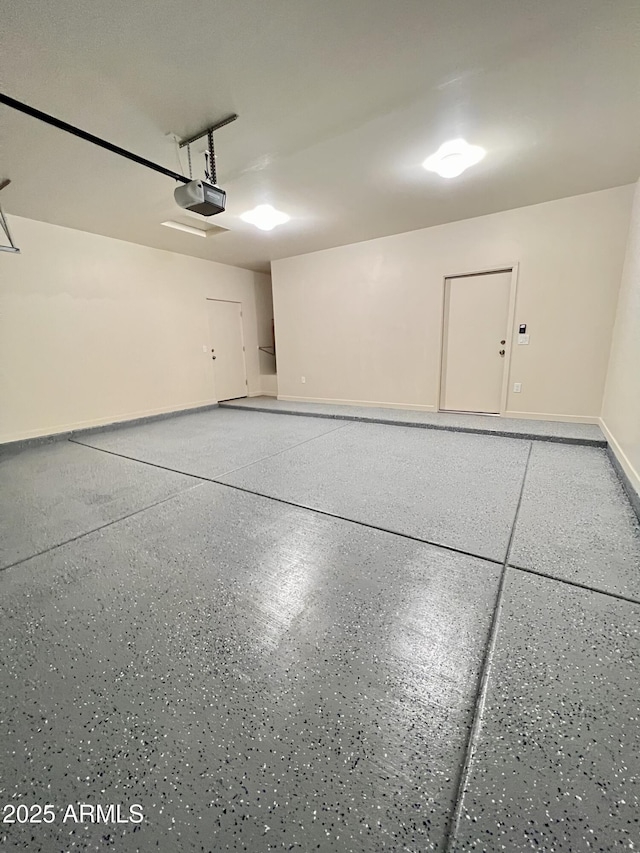 garage with a garage door opener and baseboards