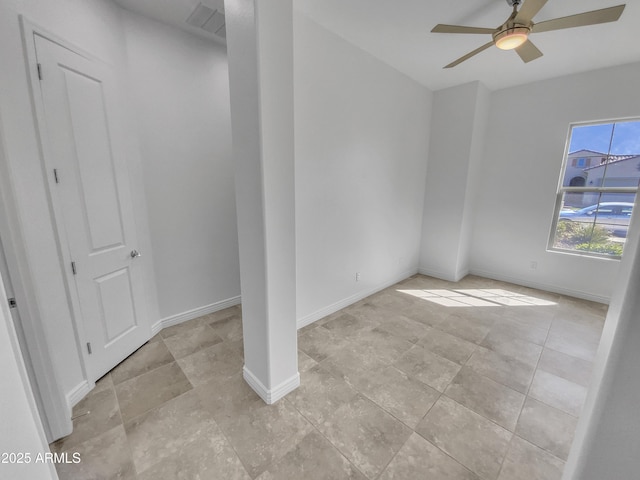 spare room featuring visible vents, a ceiling fan, and baseboards