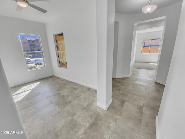 spare room featuring baseboards and ceiling fan