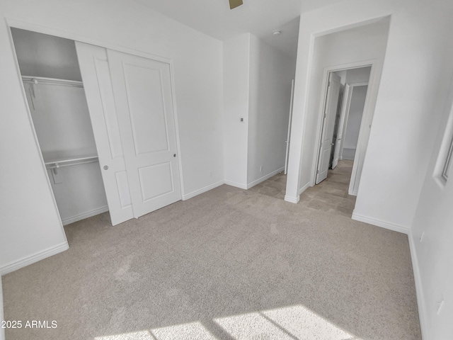 unfurnished bedroom featuring baseboards, a closet, and carpet floors