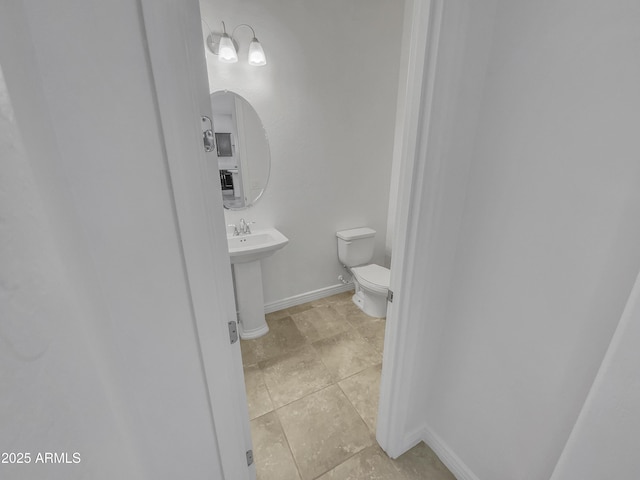 bathroom with baseboards and toilet